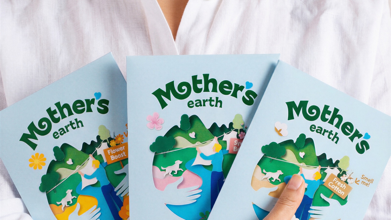 Mutter umarmt Kind neben Mother Earth Waschmittel-Blaettern